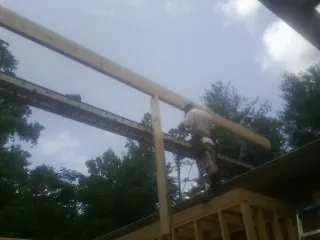 Carpenter setting a ridge beam over a new addition frame — Ice Dam Removal by Roofing Brothers in Geigertown