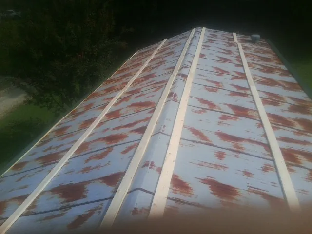 Rusted metal roof panels with new wood purlins before replacement — Storm Damage Roof Repair in Geigertown by Roofing Brothers