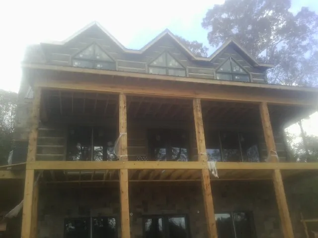 Dormers and porch framing on a large log home under construction — Roof Coating work by our crew in Geigertown