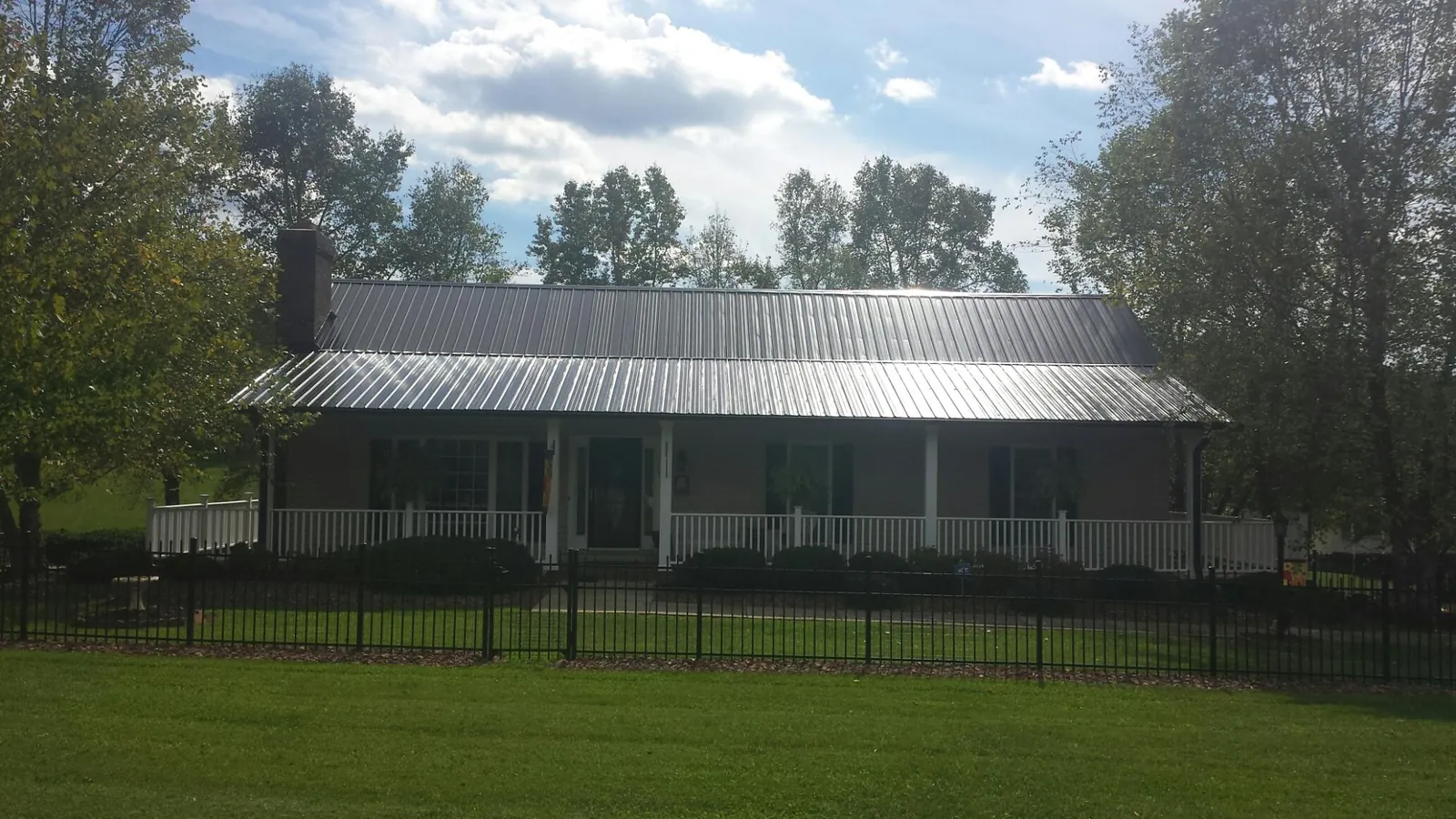 Gray metal roof on a brick ranch with a full width front porch — Gutter Guard Installation work by our crew in Geigertown