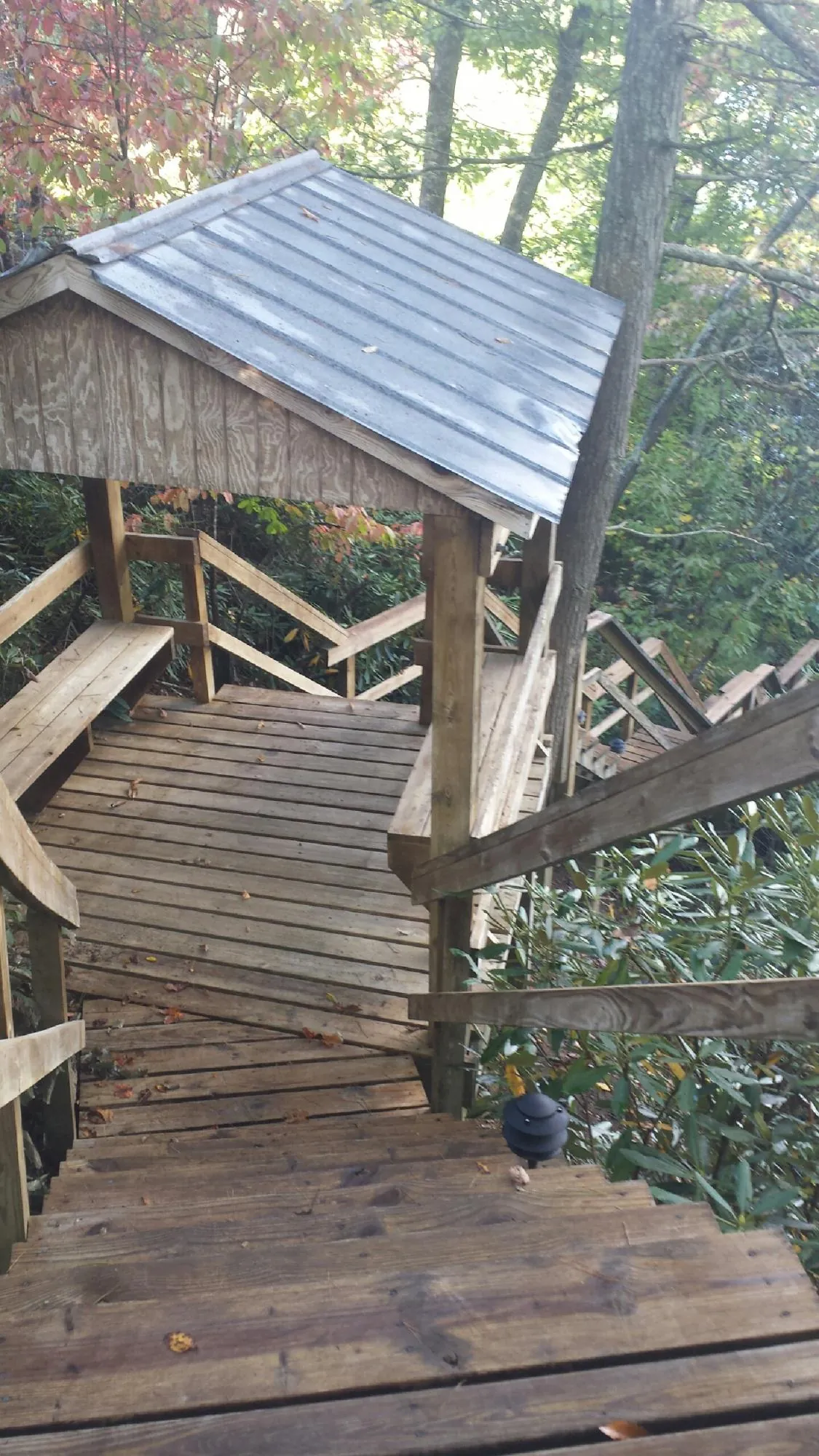 Metal roofed shelter over wooden steps on a wooded walkway — Skylight Repair & Installation work by our crew in Geigertown